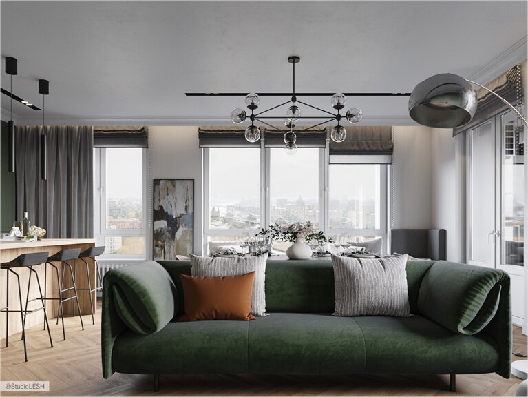 Большой зеленый диван в просторной кухне-гостиной