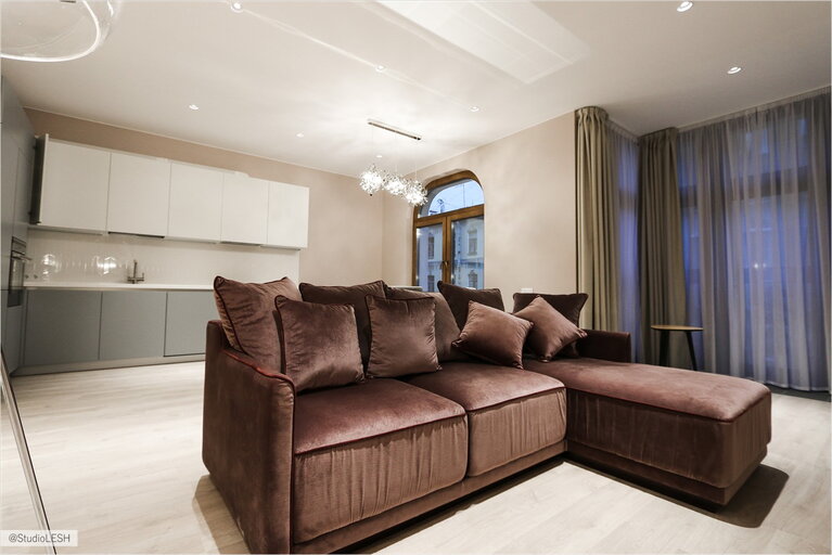 Элегантный диван в кухне-гостиной с панорамными окнами