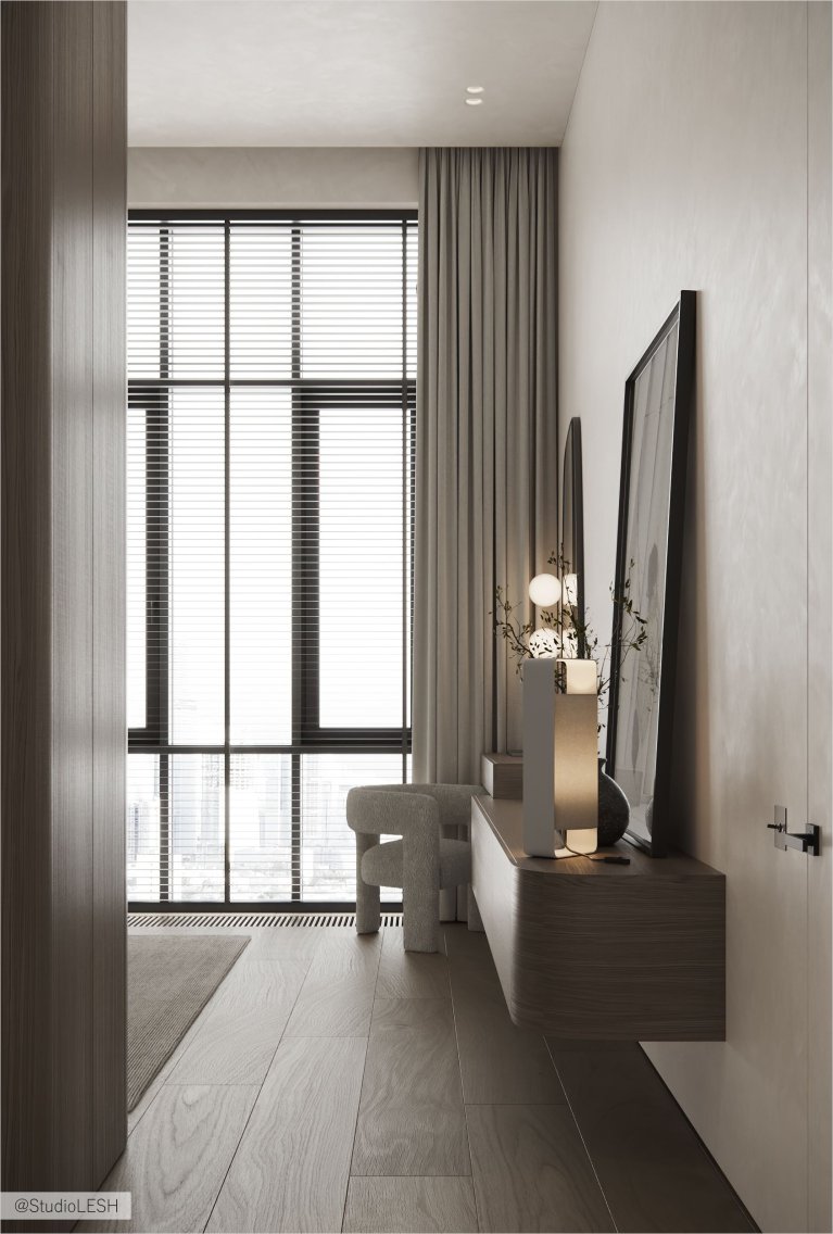 Интерьер современной комнаты с деревянным туалетным столиком, зеркалом необычной формы, мягким пуфом и картиной на стене.