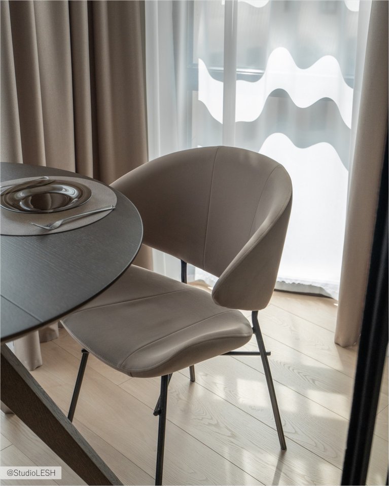 Стильный стул с мягким сиденьем и изогнутой спинкой, обтянутый светло-коричневой тканью букле. Ножки стула металлические, тонкие и прочные. Стул идеально подходит для современного интерьера кухни или гостиной