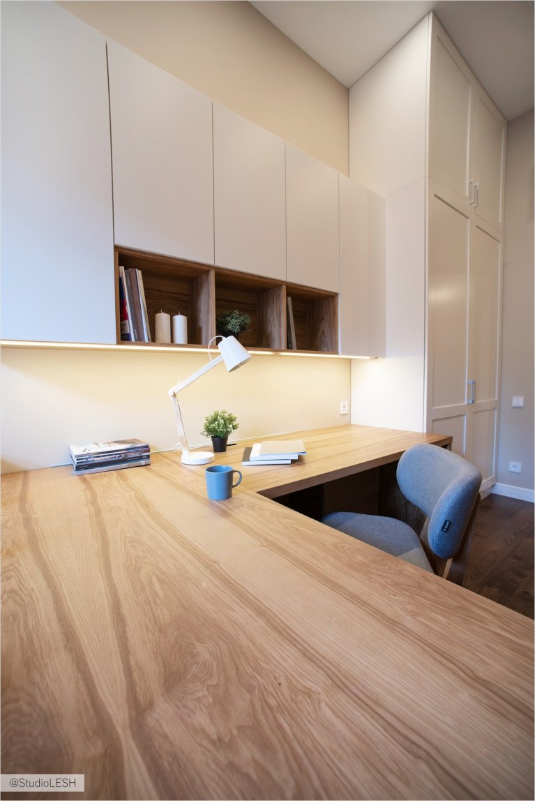 Дизайн современного домашнего офиса с деревянным столом и белыми шкафами: стильный интерьер с удобным креслом и яркими акцентами