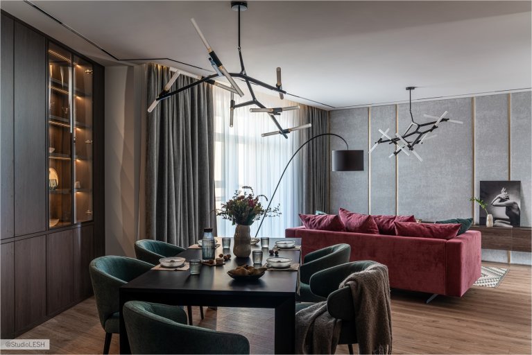 Современная гостиная с обеденной зоной, стильным диваном и оригинальными люстрами