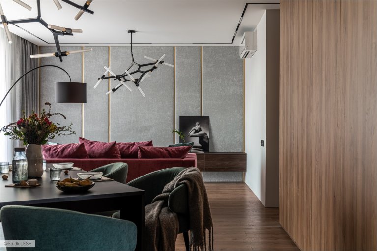 Современная гостиная с обеденной зоной, стильным диваном и оригинальными люстрами