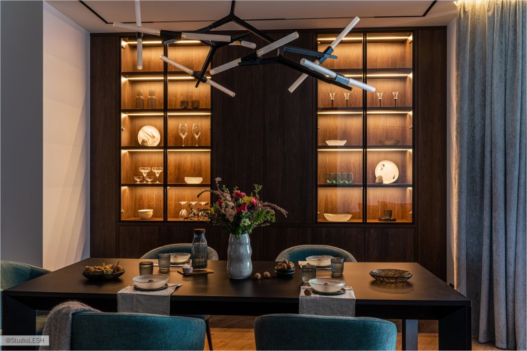 Современная столовая с обеденным столом, стильными стульями и оригинальным освещением