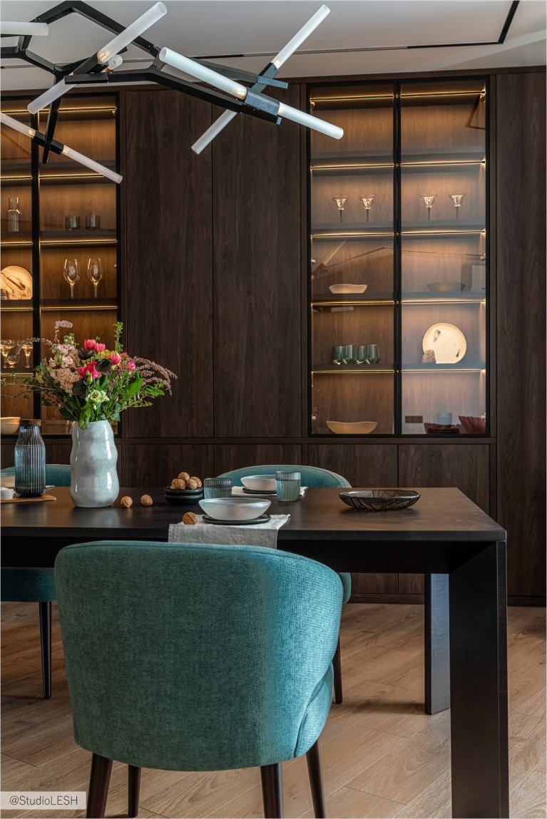 Современная столовая с обеденным столом, стильными стульями и оригинальным освещением