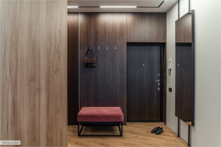 Современная прихожая с удобным пуфом, стильными шкафами и зеркалом