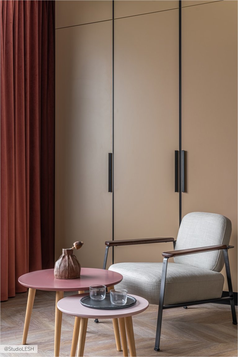 Гостиная с большим бежевым шкафом, который занимает почти всю стену