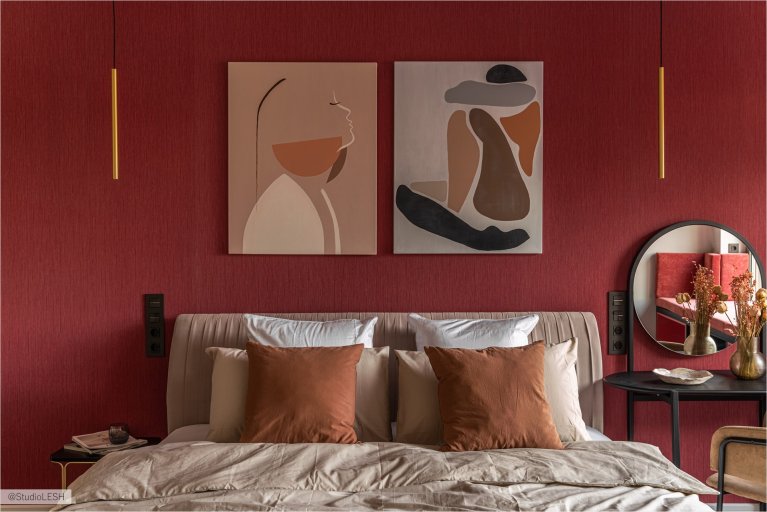 Спальня с большой кроватью с мягким изголовьем, на которой лежат декоративные подушки и покрывало