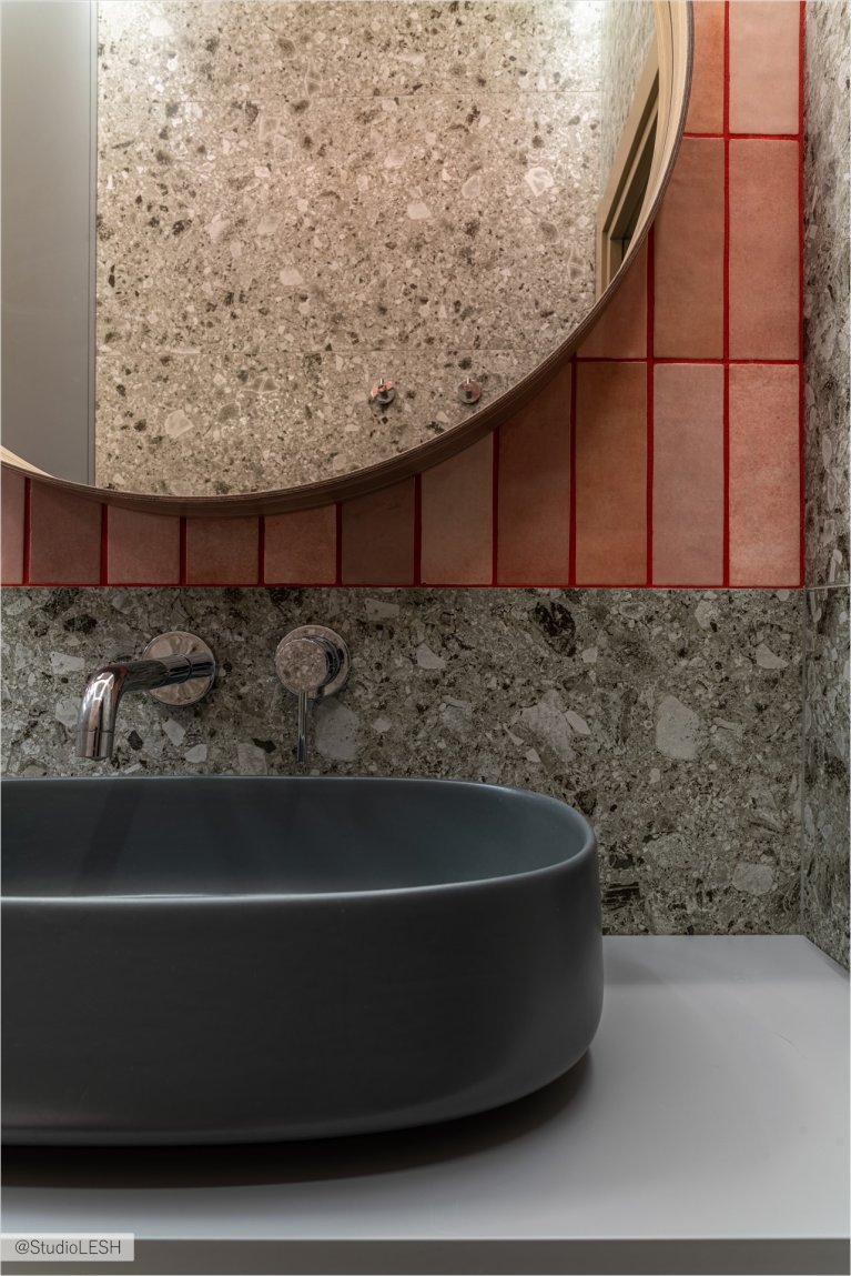 Напротив душевой кабины расположено круглое зеркало в тонкой раме